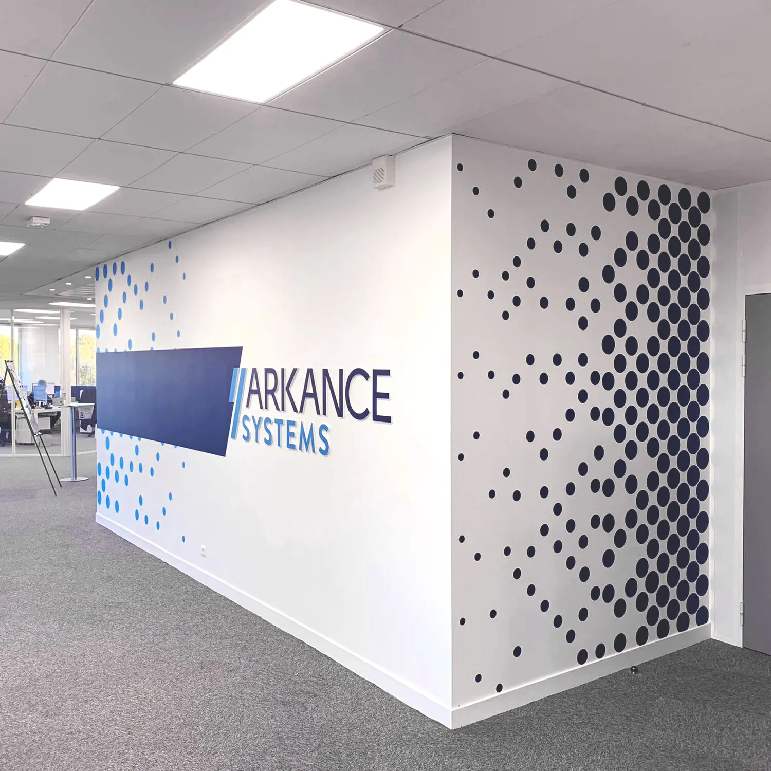 Logo Arkance Systems et motif de points sur les murs d'un open space