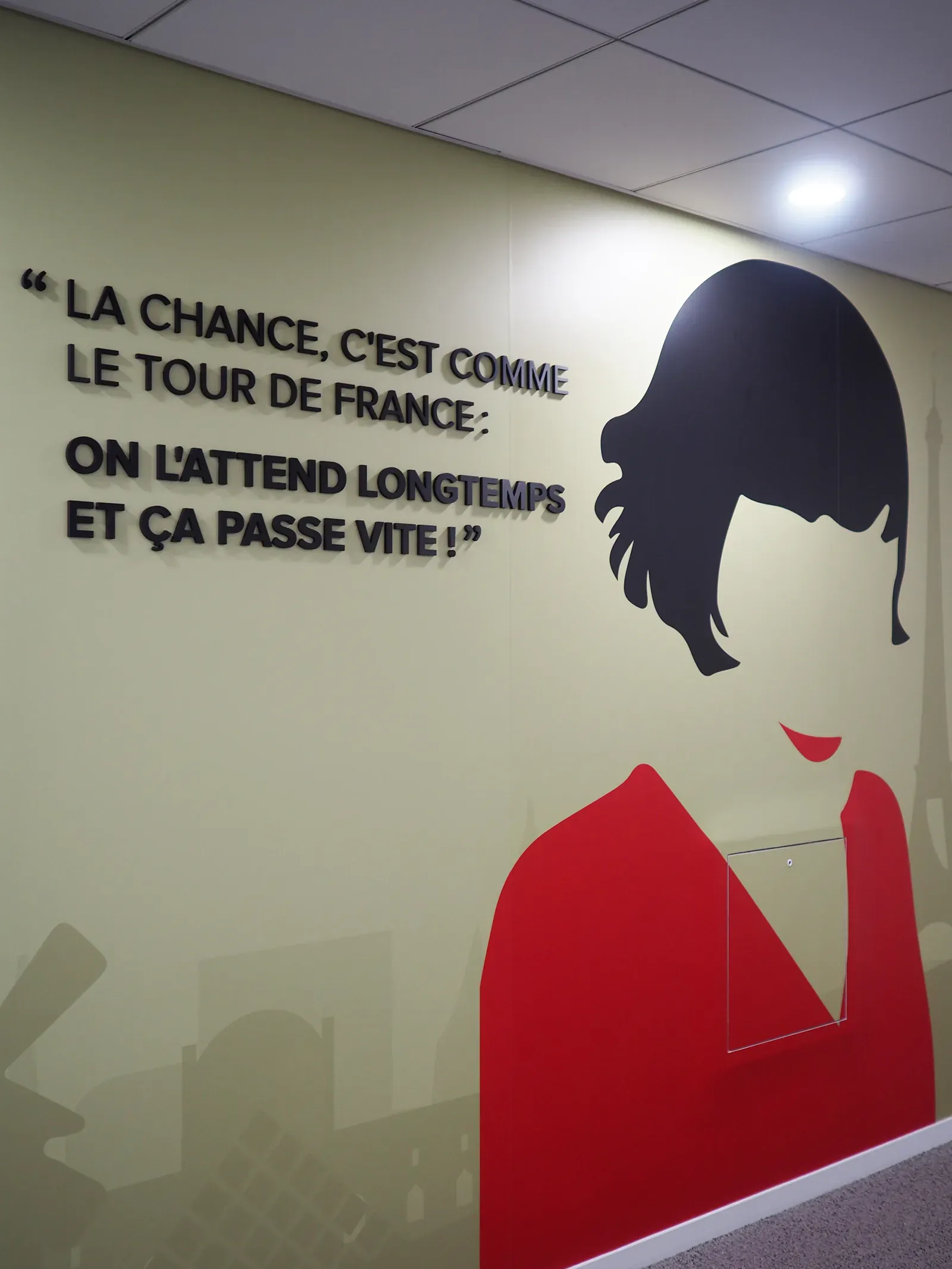Citation « La chance, c'est comme le Tour de France » en lettres noires en relief à côté d'un portrait illustré