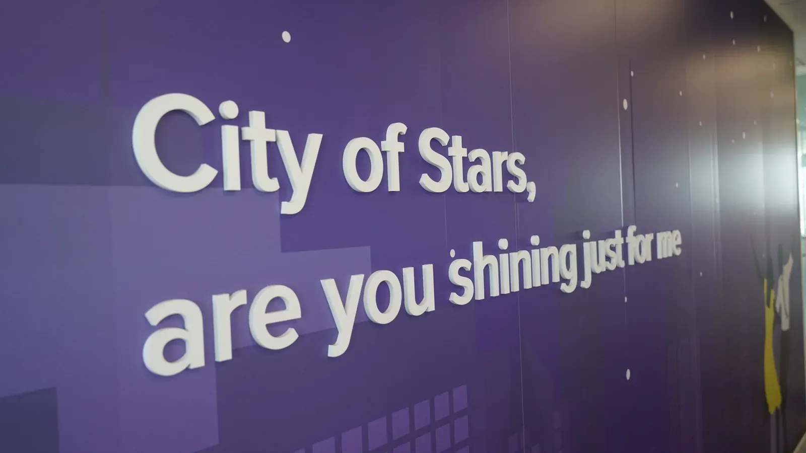 Citation « City of Stars, are you shining just for me » en lettres blanches en relief sur mur violet