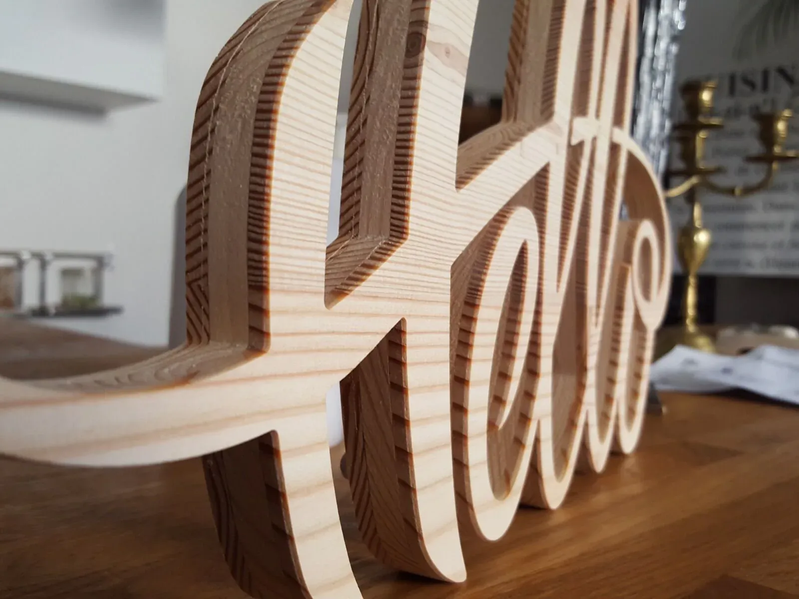 Mot Hello en lettres de bois découpées et assemblées, posé sur une table
