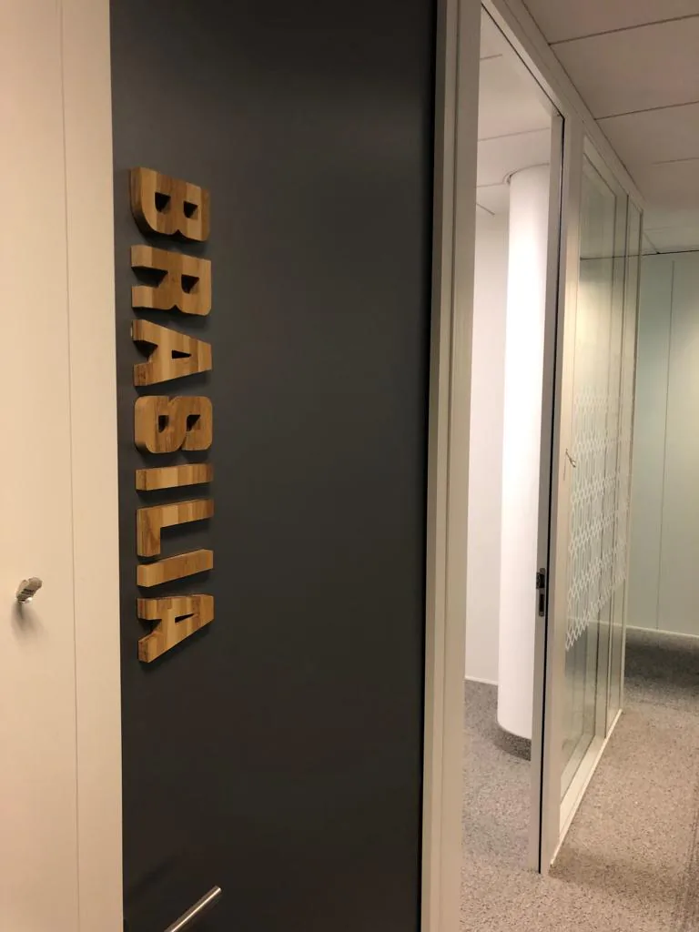 Nom de salle Brasilia en lettres bois verticales sur cloison sombre