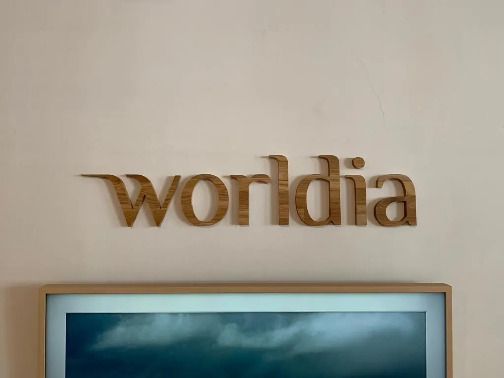 Logo worldia en lettres de bois en relief au-dessus d'un écran